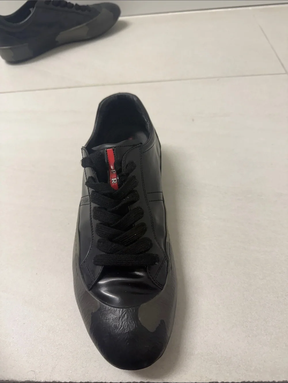 Prada Black Low-Top Leather Sneaker with Red Tongue Accent